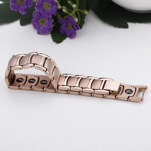 Detail of rose gold magnetic health bracelet with black magnets on inner links