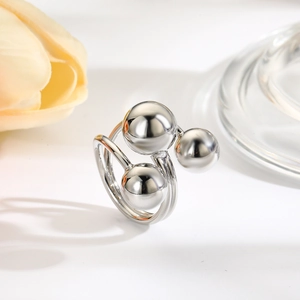 Detail of silver wire-wrapped ring featuring three polished metallic spheres on top