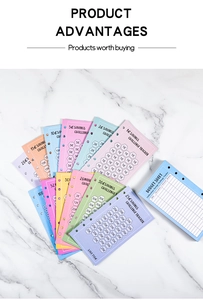 Close-up of colorful A6 6-hole savings challenge cards and budget sheets on marble