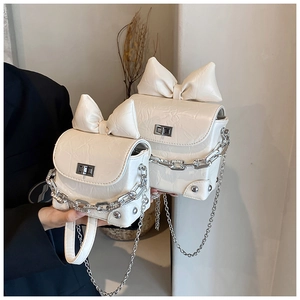 Detailaufnahme der cremefarbenen Mini-Tasche mit Vintage-Struktur und silbernem Drehverschluss