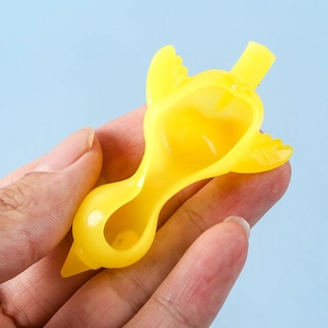 Yellow TPR rubber slingshot chicken toy being launched from a finger against blue background