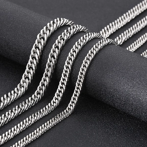 Macro shot of polished silver stainless steel cuban curb chains on a black textured display
