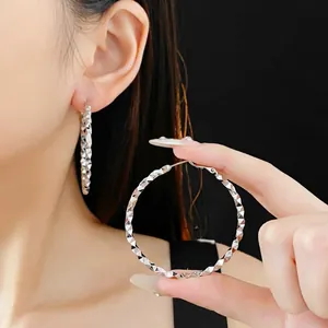 Silver textured hoop earrings with diamond-cut pattern and high-reflective finish