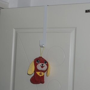 White metal over-the-door hook organizer with a festive red plush toy hanging on it