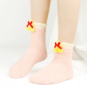 Detailansicht der rosa Fleece-Socken mit gelber Glocke und rotem Schleifen-Dekor