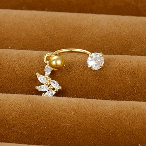 Macro shot of gold stainless steel flower cartilage piercing with white cubic zirconia