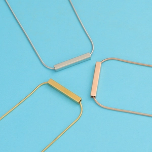 Three-color hollow rectangular tube necklaces in gold silver and rose gold on blue