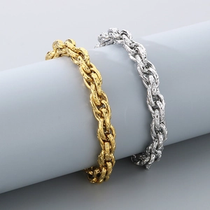 Détail de bracelets gourmettes torsadés or et argent avec maillons ciselés en losange