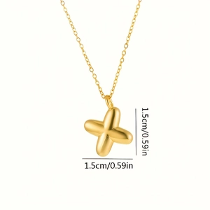 Dettaglio delle dimensioni di 1,5 cm del ciondolo a croce dorata su collana in acciaio