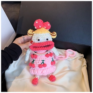 Detail of handmade crochet cartoon bag with pink lips and cherry dress on silk