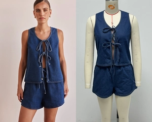 Detail of dark blue denim set featuring a tie-up vest and high-waisted shorts