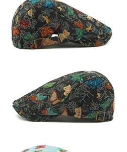 Detail of vintage jacquard newsboy cap with colorful butterfly patterns and brass buckle