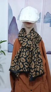 Detail shot of soft leopard print scarf in brown and black on a mannequin display