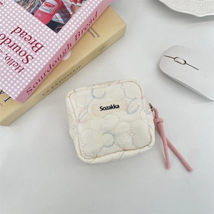 Close-up of quilted floral sanitary bag with 'Sozakka' label and pink zipper pull