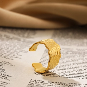 Close-up van een gouden open ring met gedetailleerde textuur en een gladde afwerking