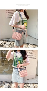 Pink quilted shoulder bag with patterned strap and zipper closure in outdoor street setting