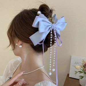 Detail of lavender satin bow hair claw with elegant long faux pearl tassel drop