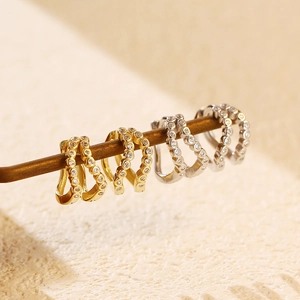 Macro shot of double-row gold and silver ear cuffs with pavé-set round cubic zirconia