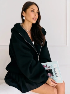 Close-up of black oversized hoodie featuring a metal zipper and comfortable hood detail