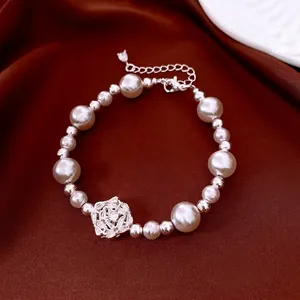 French pearl beaded bracelet with zircon flower pendant on elegant red silk background