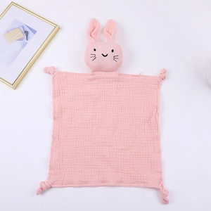 Close-up of pink cotton muslin baby security blanket with cute bunny head and knotted corners
