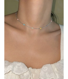 Detail of minimalist silver necklace featuring colorful enamel beads on a thin chain