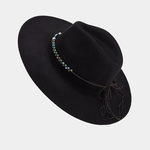 Detail of black fedora hat featuring ethnic beaded band and western tassel decoration