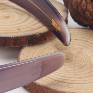 Detailed macro view of purple acetate headband tip with smooth finish and tortoiseshell texture