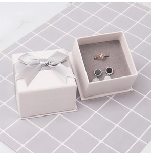 Detail of pink jewelry box with silver satin bow and grey velvet lining for rings