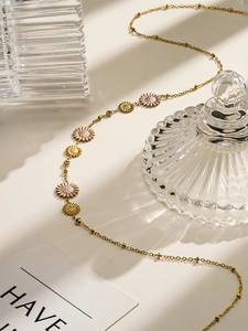 Detail of 18K gold plated titanium necklace featuring pink enamel daisies and fine crystals