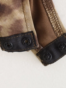 Macro detail of leopard print mesh fabric with brown lining and black snap buttons