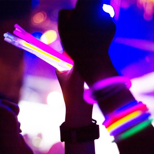 Bâtons et bracelets lumineux éclairant une fête sombre avec des couleurs néon