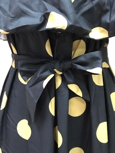 Detail der Taillenschleife am marineblauen Kleid mit großen gelben Punkten