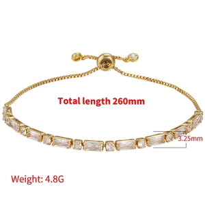 Adjustable gold bracelet with square and round zircon crystals on white background