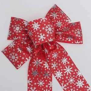 Close-up of red Christmas bow with glitter texture and silver snowflake patterns