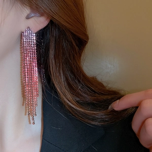 Close-up of pink rhinestone long tassel earrings showing luxurious sparkling chain details