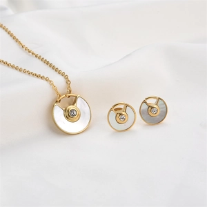 Detailed shot of gold plated necklace and stud earrings set with white enamel and crystals