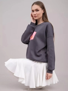 Detail eines rosa Grafikdrucks auf einem dunkelgrauen Sweatshirt mit Rundhalsausschnitt