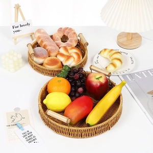 Handwoven round rattan fruit baskets with wooden handles on a clean white tabletop