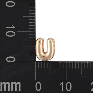 Macro shot of gold KC bubble letter U pendant on ruler showing 8mm size dimensions