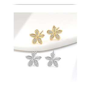 Macro detail of S925 silver flower earrings with micro-inlaid zircon in gold and silver