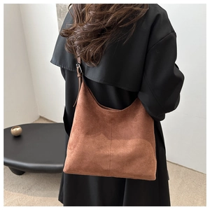 Back view of a model wearing a minimalist brown suede crescent shoulder bag with large capacity