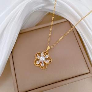 Close-up of golden hollow flower necklace with pearls and crystals on brown box