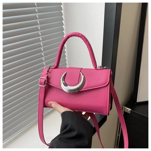 Détail du sac à main rose en cuir litchi avec une boucle métallique argentée en croissant