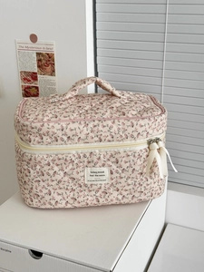 Pink floral corduroy travel cosmetic bag with quilted texture and ribbon zipper pulls