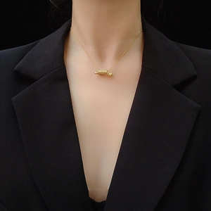 Collier élégant à pendentif spirale doré avec chaîne serpent porté par un mannequin