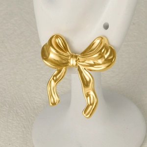 Elegant 18k gold plated stainless steel bow earrings displayed on a white model