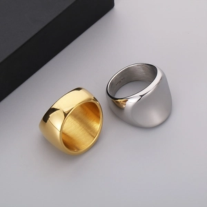 Macro shot of gold and silver wide stainless steel rings showing inner 316L engraving