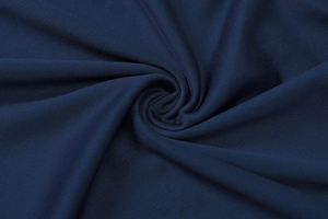 Détail macro du tricot bleu marine montrant la texture, le drapé et le tissage en spirale