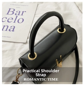 Top view of black leather cylinder bag with gold hardware and detachable shoulder strap